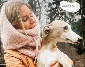 May include: A soft, light pink knitted balaclava hood with a ribbed neck section and drawstring ties. The text +VIDEO is visible in the upper right corner, and the text KNITTING PATTERN is printed in black at the bottom of the image.