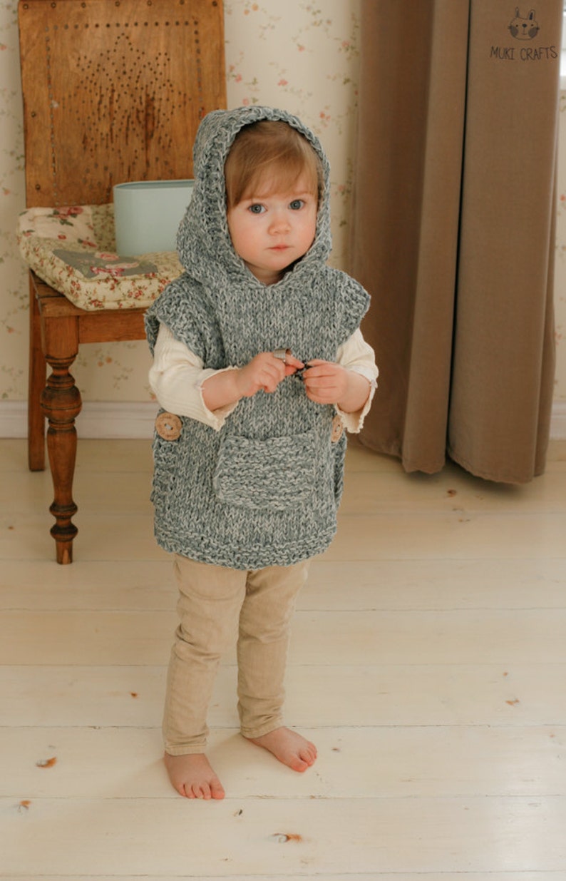 toddler in hooded knit poncho with big pocket at front