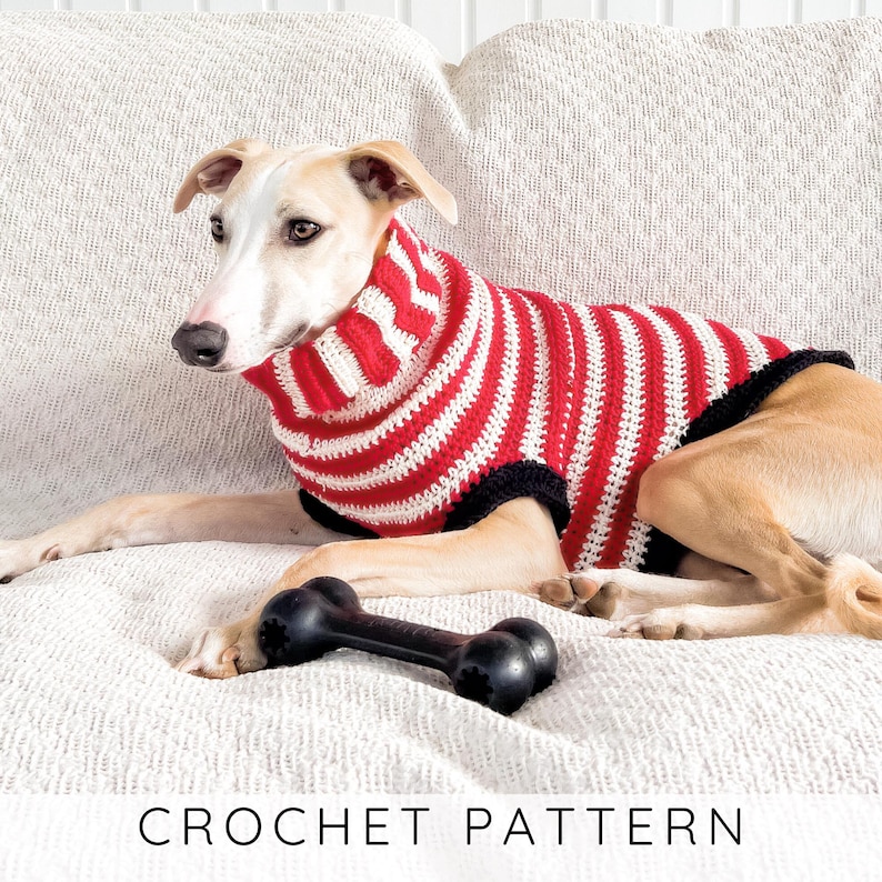 A light-colored whippet-type dog resting on a white textured couch, wearing a red and white striped crochet sweater. A black rubber dog bone toy sits in the foreground. Text at the bottom reads, "CROCHET PATTERN"