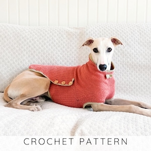 May include: A dog wearing a coral-colored crochet dog sweater with a light brown trim and wooden buttons. The dog is lying on a white couch. The text "CROCHET PATTERN" is at the bottom of the image.