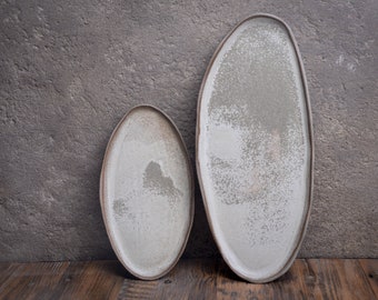 Organic natural shape elongated stoneware plates in grey cream, minimalist monochrome handcrafted handmade pottery