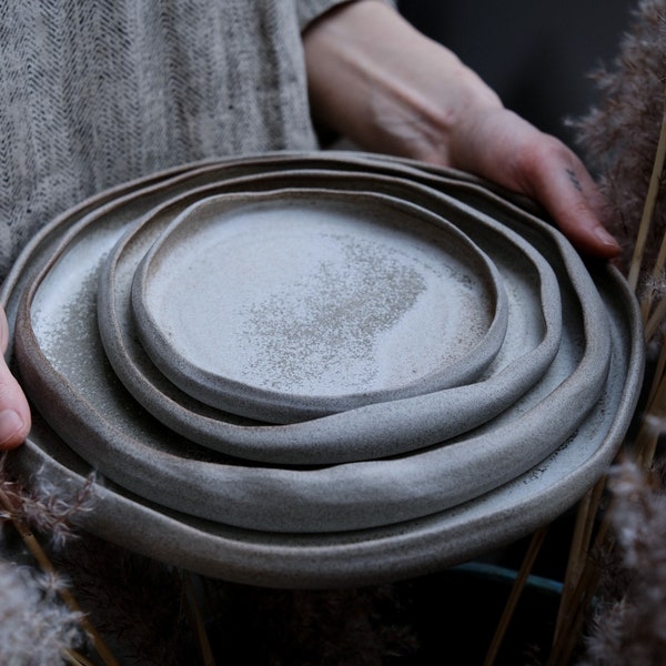 Dune organische steengoedplaten in natuurlijke vorm in grijze crème, minimalistisch monochroom handgemaakt handgemaakt aardewerk