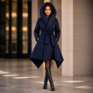 May include: A navy blue puffer coat featuring a large, oversized hood, long sleeves, and a belted waist. The coat has a structured, flared silhouette with an asymmetrical hemline that falls below the knees, paired with black knee-high leather boots.