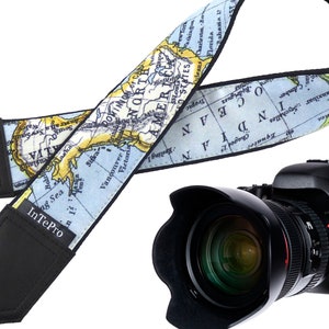 May include: A camera strap with a world map design. The strap is blue and yellow with a black border. The strap is attached to a black camera with a lens.