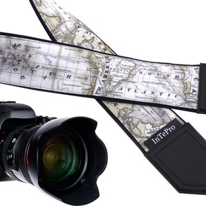 May include: A black camera strap with a vintage world map design. The strap has a black leather pad with the text "InTePro" printed in white.