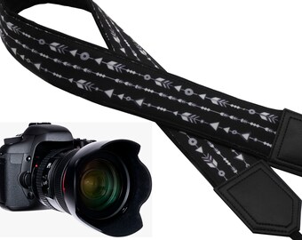 Bracelet de caméra InTePro noir et blanc avec flèches.  Flèches blanches sur dessin noir. Accessoire d’appareil photo cadeau unique. Accessoire cadeau.