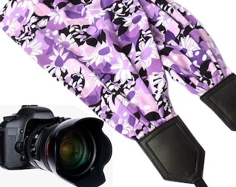 Scarf camera strap with violet and white flowers.