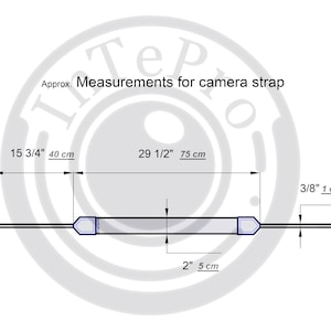 May include: Diagram showing the measurements of a camera strap. The strap is 15 3/4 inches (40 cm) long and 2 inches (5 cm) wide. The strap has two adjustable ends, each measuring 3/8 inch (1 cm) wide.