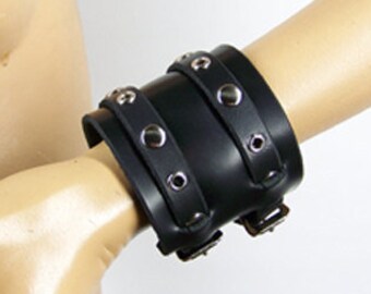 May include: Black leather wrist cuff with silver metal studs and buckles.