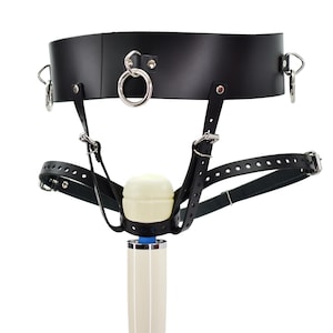May include: Black leather harness with a white and silver toy attached. The harness has multiple straps and buckles.