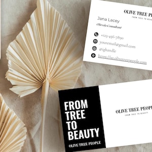 May include: Business cards with the text "Olive Tree People" and contact information. One card has a photo and QR code. Dried palm leaves and a wooden element are in the background.
