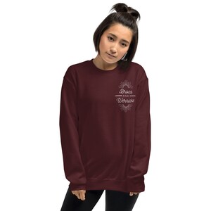 May include: A maroon sweatshirt with the text "Broca and Wernicke" in white, featuring a sunburst design. The sweatshirt is a solid colour and has a crew neck.