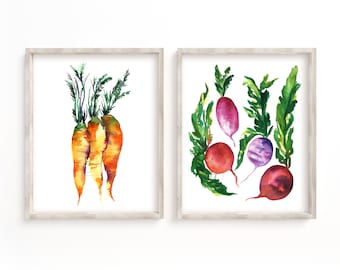 May include: Two framed watercolor paintings of vegetables. The first painting shows three orange carrots with green tops. The second painting shows four red and purple radishes with green tops.