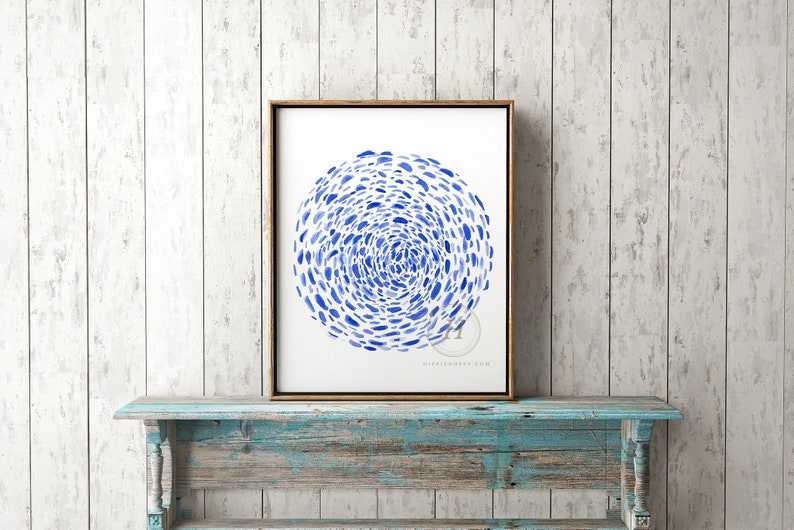 May include: A framed watercolor painting of a blue abstract circle design on a white background. The circle is made up of many small blue dots that are arranged in a swirling pattern.