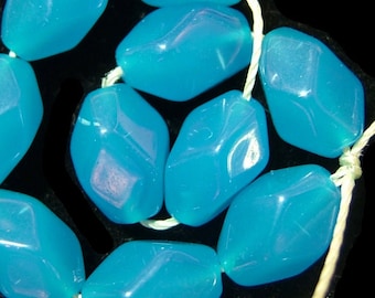 May include: A strand of turquoise blue faceted gemstone beads strung on white thread. The beads are irregular in shape and have a glossy finish.