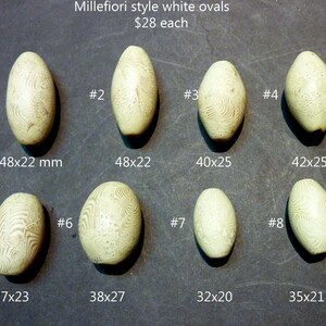 May include: Eight white oval-shaped glass beads with a millefiori pattern. The beads are arranged in two rows of four. Each bead is labeled with a number from 1 to 8. The dimensions of each bead are listed below the bead.  Millefiori style white ovals $28 each