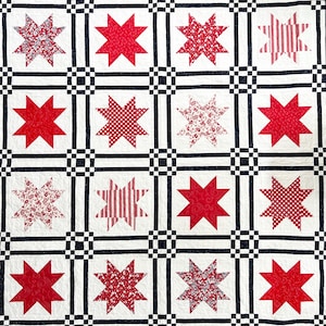 Könnte beinhalten: Ein Quilt mit einem Gitter aus weißen Quadraten, die durch schmale schwarze Streifen und kleine schwarze Eckquadrate getrennt sind. Jedes weiße Quadrat enthält einen roten achtstrahligen Stern. Die Sterne variieren in Mustern wie einfarbig, kariert, gestreift und floral.