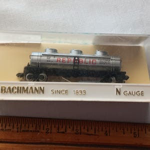 May include: A silver and black Bachmann N gauge model train car with the word "REPUBLIC" in red. The model is in a clear plastic case with the text "BACHMANN SINCE 1833".