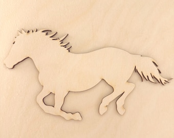 Op de afbeelding: Een platte, lichtgekleurde houten uitsparing in de vorm van een galopperend paard. Het silhouet heeft een gedetailleerde manen en staart met gladde, lasergesneden randen, die de natuurlijke nerf en textuur van het lichtbeige houtmateriaal tonen.