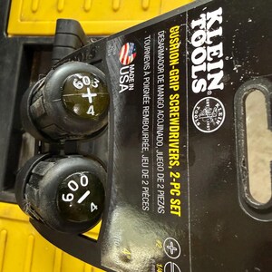 May include: A Klein Tools 2-piece cushion-grip screwdriver set on a black retail display card. The handles are black with white text indicating sizes 603-4 and 600-4. The packaging features the Klein Tools logo, Made in USA text, and a US flag icon.