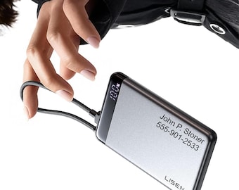 May include: A rectangular silver portable power bank with a black trim and a digital display showing 100%. The device features a black braided cord loop and is printed with the text John P. Stoner, 555-901-2533, and the brand name LISEN.