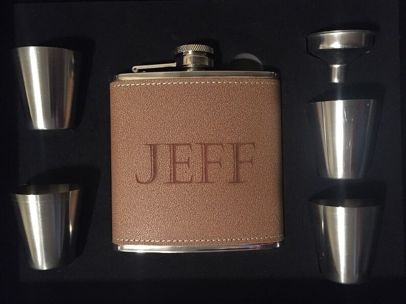 Pu&ograve; includere: Un set di fiaschetta personalizzato in una scatola nera. La fiaschetta marrone rivestita in pelle &egrave; incisa con il nome "JEFF". Il set include quattro bicchierini in acciaio inossidabile e un imbuto. Un'ottima idea regalo.