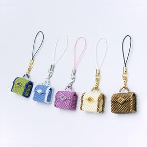 May include: Five miniature beaded purses with different colored straps and beads. The purses are green, blue, purple, white, and brown.