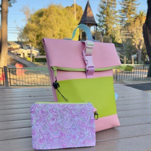 May include: A handmade wooden sign with the text "Welcome" in a handwritten style. The sign is painted white with a distressed finish and features a decorative floral design in shades of pink and green. It is designed to be hung on a wall.