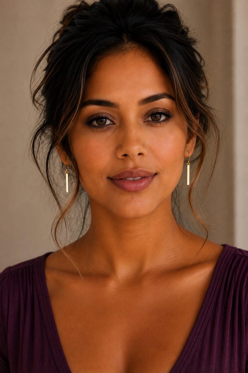 May include: A pair of gold-toned drop earrings featuring a slender, vertical rectangular bar design. The earrings hang from simple wire hooks, showcasing a polished metallic finish that catches the light, creating a clean and understated appearance.