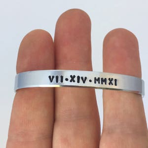 May include: A silver bracelet with the inscription "VIII-XIV-MMXI" engraved on it.
