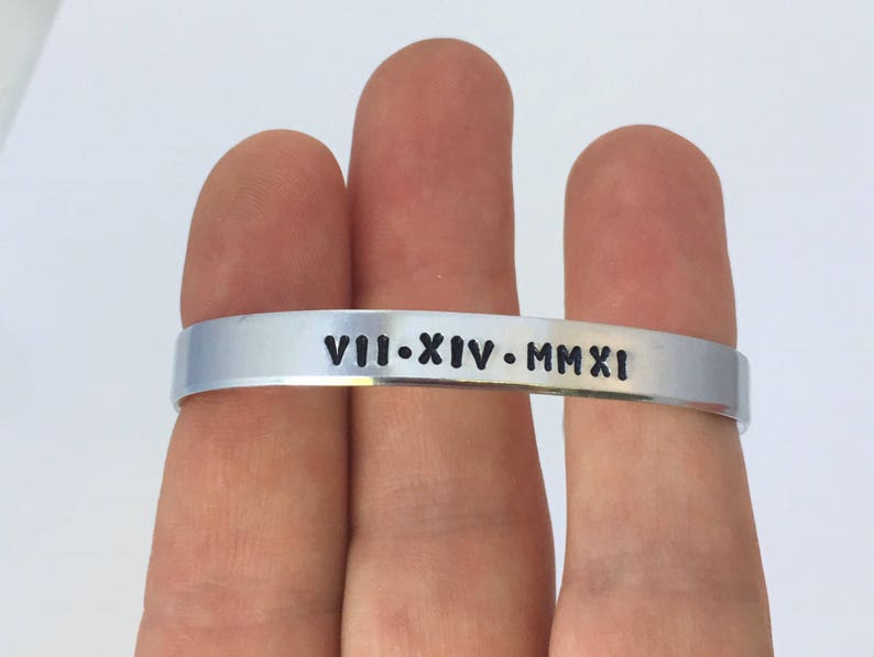May include: A silver bracelet with the inscription "VIII-XIV-MMXI" engraved on it.