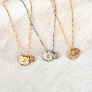 May include: Three gold necklaces with a baseball charm and a letter charm. The charms are engraved with the letters "M", "C", and the number "10".