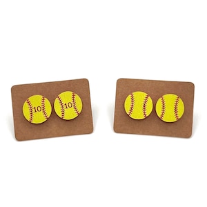 May include: A pair of softball earrings with the number 10 on each earring. The earrings are on a brown card.