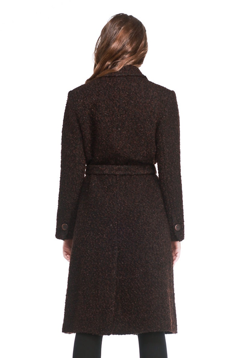 May include: A brown tweed coat with a belt and long sleeves. The coat has a classic design and is perfect for autumn and winter.