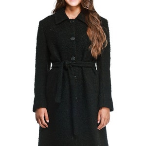 May include: A black long-sleeved coat with a belt and button closure. The coat has a textured fabric and a classic style.