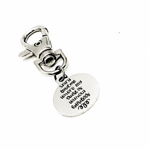 May include: Silver keychain with a round charm that says "Spirit lead me where my trust is without borders".