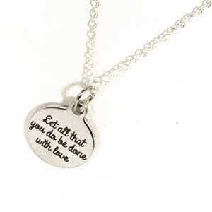 May include: Silver necklace with a round pendant that says "Let all that you do be done with love".