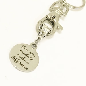 May include: Silver keychain with a round charm that says "You were made to make a difference".