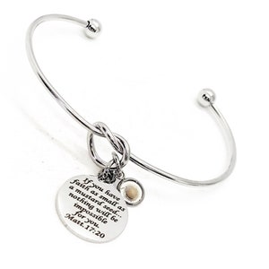 May include: Silver bangle bracelet with a knotted charm and a round charm with the text "If you have faith as small as a mustard seed... nothing will be impossible for you. Matt. 17:20".