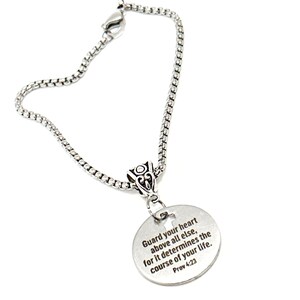 May include: A silver chain bracelet with a round pendant that has the inscription "Guard your heart above all else, for it determines the course of your life. Prov 4:23".