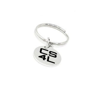 May include: Silver keychain with a round metal tag that says "CS4L" in black lettering.
