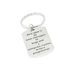 May include: Silver keychain with a rectangular tag that reads "All it takes is 20 error messages, 75 bugs and 3 computer crashes to be a programmer".