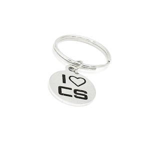 May include: A silver keychain with a round charm that says "I love CS" with a heart symbol.