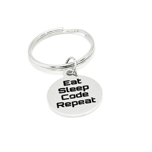 May include: Silver keychain with a round charm that says "Eat Sleep Code Repeat" in black text.