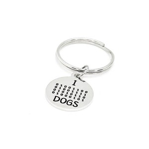 May include: Silver keyring with a round charm that says "I  DOGS" in binary code.