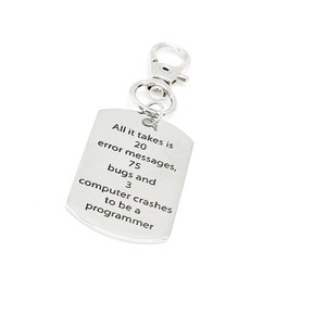 以下が含まれることがあります： 「プログラマーになるには、20のエラーメッセージ、75のバグ、そして3回のコンピュータークラッシュが必要だ」と書かれたタグが付いたシルバーのキーホルダーです。