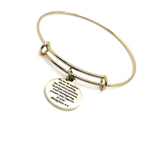 May include: Gold bangle bracelet with a charm that reads "Do not be anxious about anything, but in every situation, by prayer and petition, with thanksgiving, present your requests to God. Philippians 4:6"