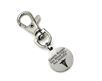 May include: Silver keychain with a round tag that says "Gastric Bypass No Blind NG. No NSAIDS." with a medical symbol.