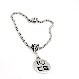 May include: A silver chain bracelet with a silver charm that says "I love CS" with a heart in place of the "O".
