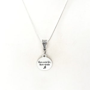 May include: Silver necklace with a round pendant that says "When words fail... Music speaks" with a musical note symbol.